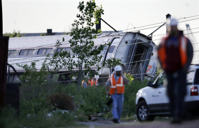 Emergency personnel walk near the scene of a deadly train wreck on Wednesday in Philadelphia. Mel Evans/AP