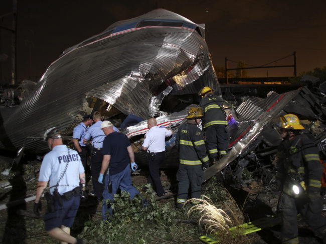 Emergency personnel search through the wreckage of an Amtrak train that derailed Tuesday night in Philadelphia, killing at least five people who were on board. Joseph Kaczmarek/AP