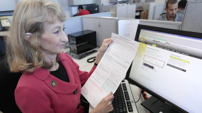 Debra Bowen, then California secretary of state, demonstrates the state's online voter registration system when it was launched in 2012. Voters can also still register using a paper form. Rich Pedroncelli/AP