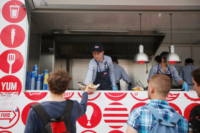A man serves hamburgers at the USA Pavilion's food truck at Expo 2015 in Rho, near Milan, Italy. The Food Truck Nation exhibit highlights America's urban food truck trend. Luca Bruno/AP