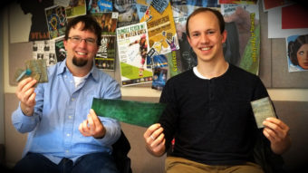 Zach Wilkinson and Craig Kasberg of Tidal Vision showing their salmon leather wallets in the KXLL studio. (Photo by Annie Bartholomew/KTOO)