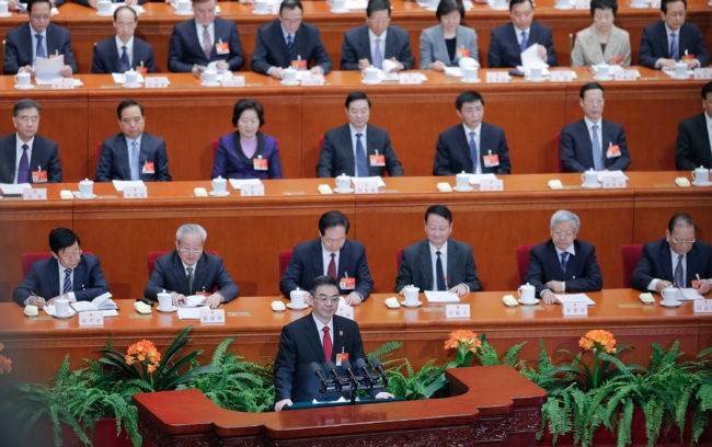 Zhou Qiang, president of the Supreme People's Court of China, speaks to the National People's Congress in Beijing on March 12. Chinese authorities are waging a major campaign against corruption, and that includes a list of 100 suspects believed to be overseas. Many are former officials who are thought to have fled to the U.S. or Canada. Lintao Zhang/Getty Images