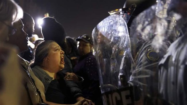 A protester yells at police outside the Ferguson Police Department, Wednesday, March 11, 2015, in Ferguson, Mo. (Associated Press)