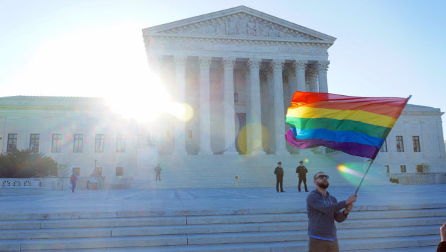 A man waves a gay pride flag on the steps of the Supreme Court of the United States while arguments are heard on legalizing same-sex marriage. (Photo by Ted Eytan)