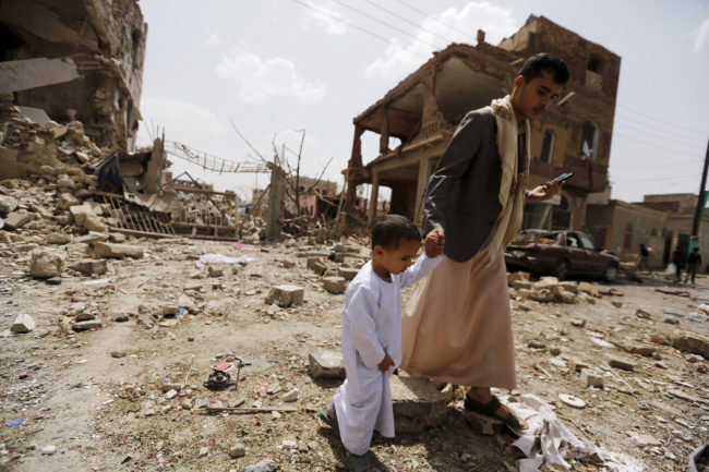 A man and a boy walk at a site hit by a Saudi-led air strike in Yemen's capital Sanaa on July 3. More than a million civilians have been displaced in recent fighting. Khaled Abdullah/Reuter