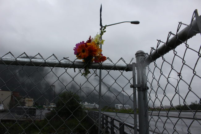 Flowers stuck in the fence above the bridge as memorial. (Photo by Elizabeth Jenkins/KTOO) 