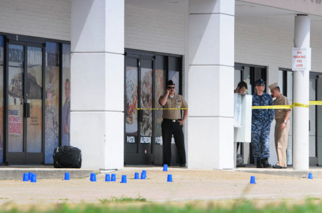 Reserve Recruitment personnel stand outside a military recruiting center on Lee Highway in Chattanooga, Tenn., as the area is cordoned off with blue shell casing markers. Officials said two military facilities in Tennessee were attacked in shootings Thursday. Tim Barber/Chattanooga Times Free Press via AP