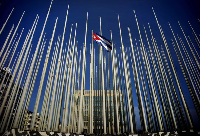 A Cuban flag flies among empty flag polls that obscure the then U.S. Interests Section. That building has again become the U.S. Embassy in Havana. Ramon Espinosa/AP