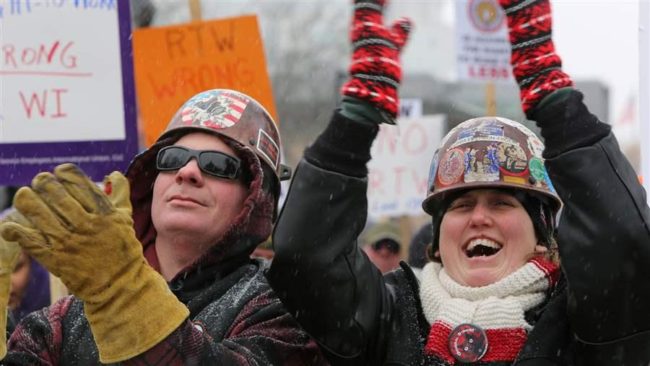 Chris Trapp and Melissa Emerson-Froebe of Iron Workers Local 8 in Milwaukee attend a rally against a Wisconsin right-to-work bill outside the state capitol. The measure passed. About two dozen states took up right-to-work bills or bills to repeal prevailing wage laws this year. AP