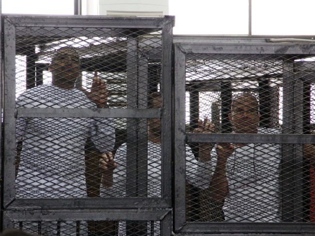 Al-Jazeera English journalists Mohammed Fahmy, left, Baher Mohamed, center, and Peter Greste, right, appeared in a cage during their trial on terrorism-related charges in Cairo in March 2014. The journalists denied all charges. Greste, an Australian, was released earlier this year, but Fahmy, a Canadian-Egyptian, and Mohamed are still on trial. Heba Elkholy/AP