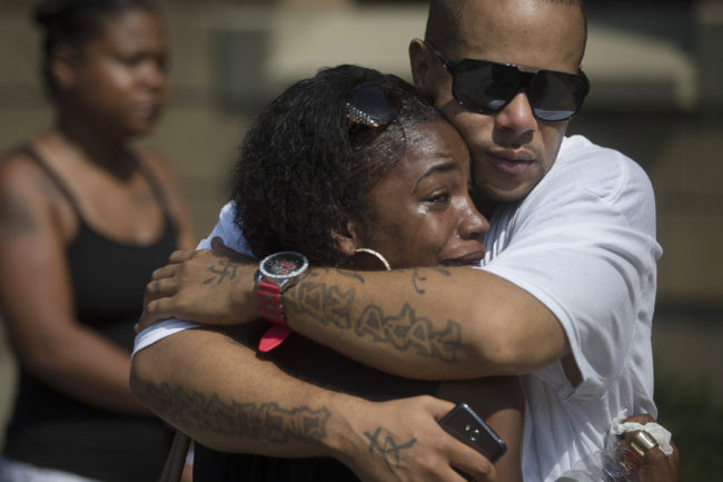 Mourners Shanicca Soloman cries in the embrace of friend Terrell Whitney outside funeral services for Samuel DuBose at the Church of the Living God in the Avondale neighborhood of Cincinnati on Tuesday. John Minchillo/AP