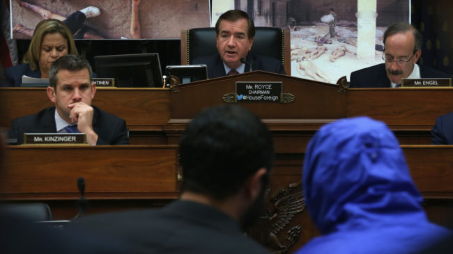 Rep. Ed Royce (center), R-Calif., speaks during a July 2014 hearing of the House Foreign Affairs Committee, with "Caesar," a Syrian army defector who wore a blue, hooded jacket to protect his identity. Caesar smuggled out of Syria more than 55,000 photographs that document the torture and killings in Syrian prisons. Alex Wong/Getty Images