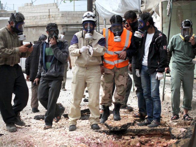 Civil defense workers wear gas masks near damaged ground in a village near the Syrian city of Idlib in May. Activists said there had been a chlorine attack. Abed Kontar/Reuters