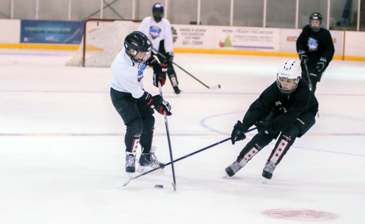Kaleah Haddock strips Gabe Miller of the puck during a drill at Treadwell Ice Arena. (Photo by Steve Quinn)