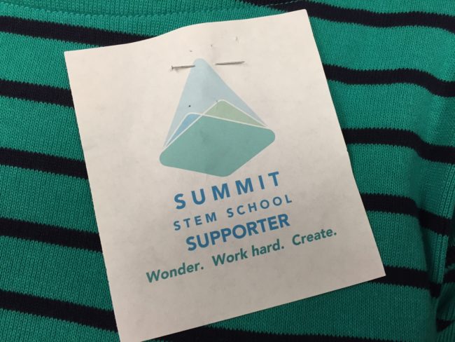 Advocates for the Summit STEM School wore these pinned to their shirts. Alberta Jones,  a member of the school's formation committee, says the logo is incomplete. (Photo by Lisa Phu/KTOO)