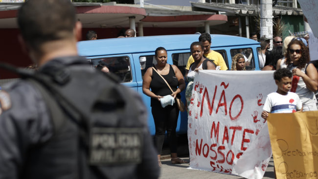 Protesters hold a sign Saturday that reads, in Portuguese, "Don't kill our children," in a march against police and gang conflicts that have left residents of the Complexo de Alemao favela in the crossfire. Silvia Izquierdo/AP