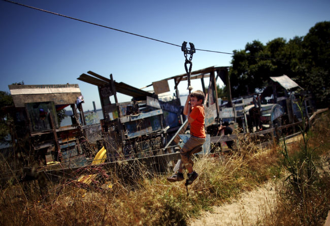 Joseph Straus, 6, rides a zip line at the Berkeley Adventure Playground, where kids can "play wild" in a half-acre park that has a junkyard feel. David Gilkey/NPR
