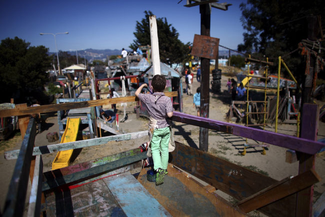 A boy paints the railings of a wooden fort at the Berkeley Adventure Playground. Nails, hammers, and buckets of paint are just part of the fun. David Gilkey/NPR