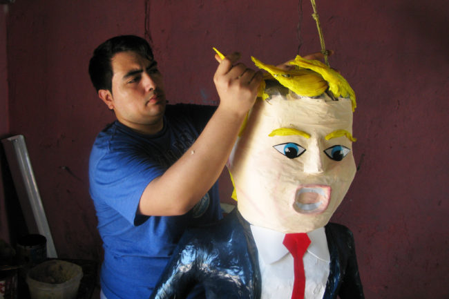 Dalton Javier Ramirez, a 28-year-old piñata maker from Reynosa, Mexico, works on his popular new creation — a piñata of Republican presidential candidate Donald Trump. John Burnett/NPR