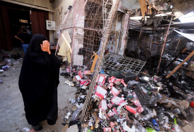 An Iraqi woman stands amid the debris following a suicide car bomb attack carried out by the Islamic State north of Baghdad, on July 18. The extremist group still holds much of western Iraq despite the U.S. air campaign that began a year ago. Ahmad Al-Rubaye/AFP/Getty Images