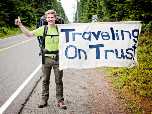 Josh deLacey poses with his sign that reads 'Traveling On Trust'. He hitchhiked 6,745 miles after he graduated college as a social experiment. Calvin College