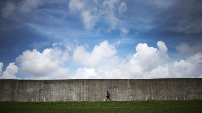 A woman walks along the rebuilt Industrial Canal levee wall in the Lower Ninth Ward on May 18, 2015 in New Orleans. Mario Tama/Getty Images