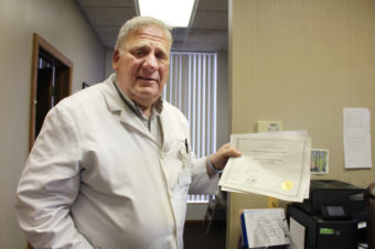 Dr. David Burkons holds the licensing certificates that allowed him to open a clinic that provides medical and surgical abortions. It took about 18 extra months of inspections, he says, to get the approval to offer surgical abortions. Sarah Jane Tribble/WCPN