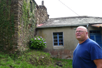 Mark Adkinson, a Briton who lives in Spain, runs a real estate agency selling abandoned villages and other historic properties. Here Adkinson stands amid buildings for sale in the abandoned village of O Penso. Lauren Frayer for NPR