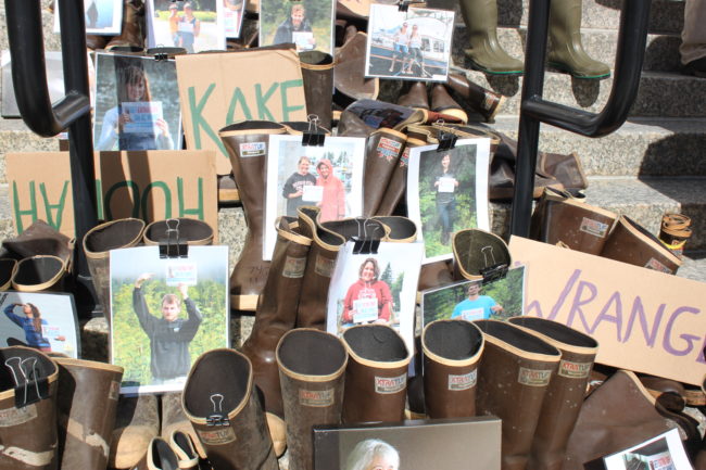 Pictures of Southeast Alaska residents and about a hundred pairs of Xtratuf boots lined the Capitol steps. (Photo by Lisa Phu/KTOO)