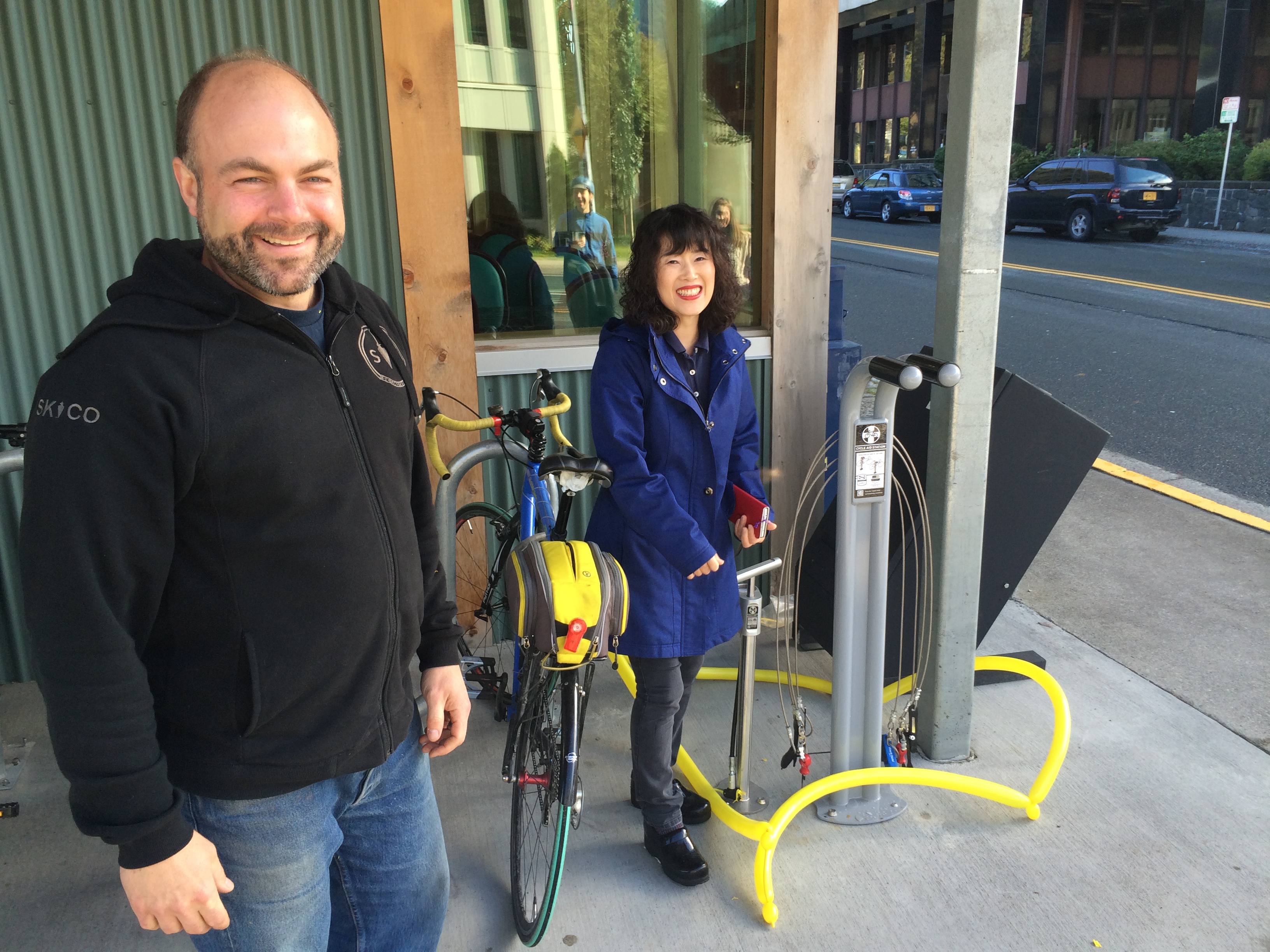 Instead of a ribbon cutting, project organizers Marc Wheeler and Jeong Kim used the new bike station's pump to pop a balloon. (Photo by Scott Burton/KTOO)