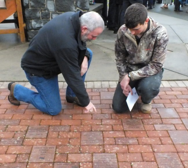 Juneau residents remember first responders whose names have been engraved in bricks at Riverside Rotary Park. (Photo by Matt Miller/KTOO)