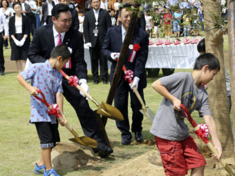 Noraha Mayor Yukiei Matsumoto, rear left, plants a tree with children of Naraha residents during an event in Naraha, Fukushima, northern Japan, on Saturday. Koji Sasahara/AP
