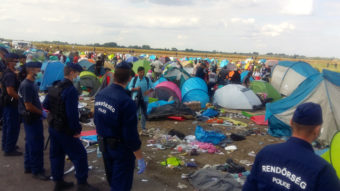 Hungarian police guard hundreds of migrants and refugees