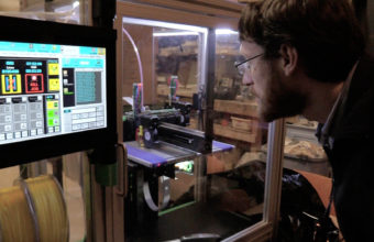 Sam Bornstein looks into the 3D printer at Juneau Makerspace