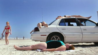 Vacationers lie on the beach, as well as their vehicle, as they sunbathe in Daytona during spring break. Only 17 miles of beach are currently open for car use and that number may soon be reduced. (Photo by Joe Raedle/Getty Images)