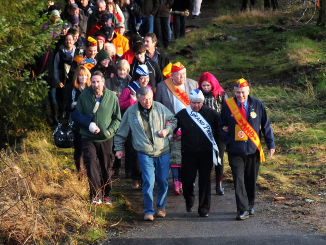 Roy Peratrovich Jr. (from left at front), Alaska Native Sisterhood Grand President Johanna Dybdahl, and Alaska Native Brotherhood Grand President Sasha Soboleff lead the procession to the new Brotherhood Bridge that includes Peratrovich's family and transportation officials. (Photo by Matt Miller/KTOO)