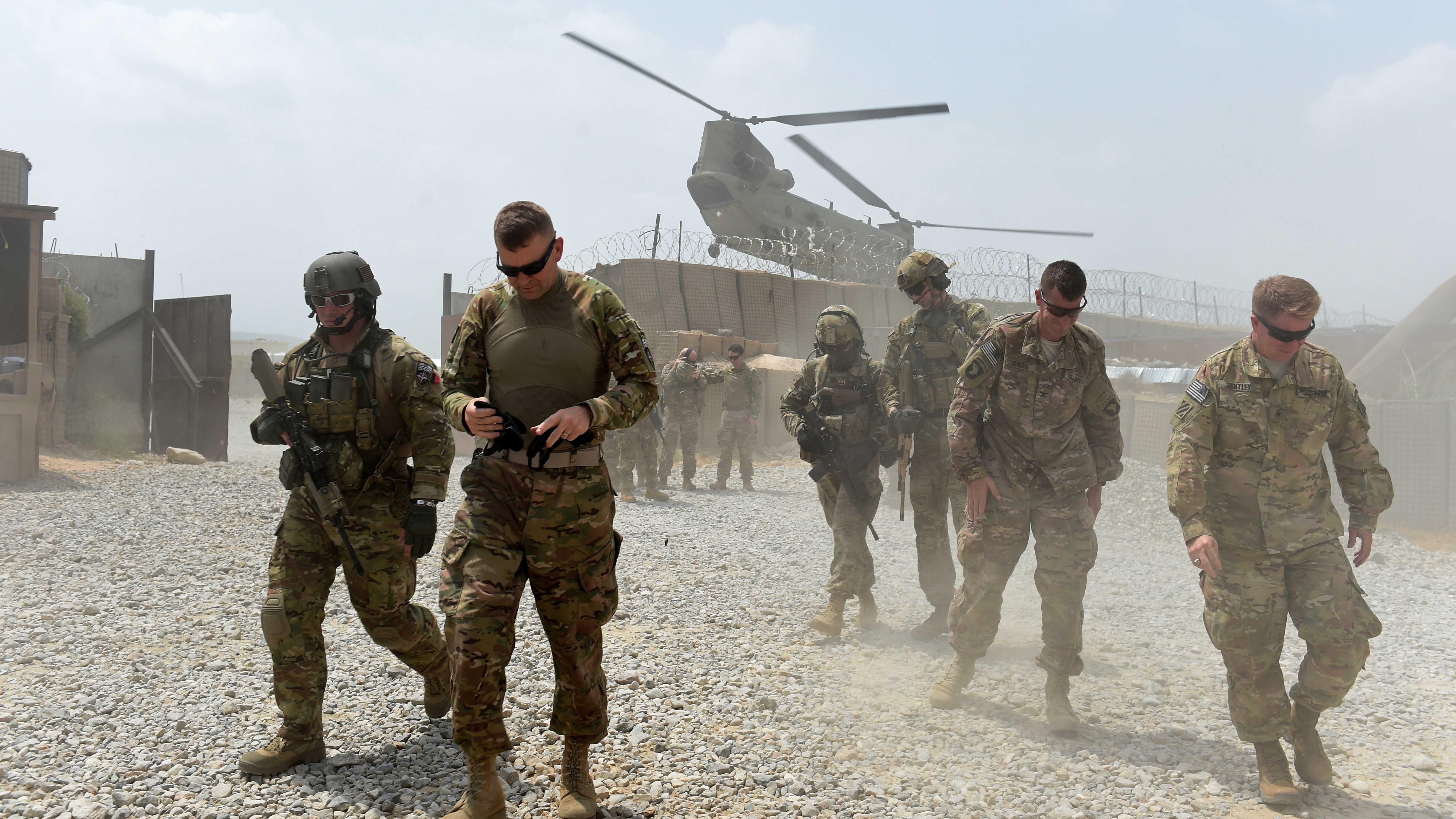 U.S. Army soldiers walk as a NATO helicopter flies overhead at coalition force Forward Operating Base (FOB) Connelly in the Khogyani district in the eastern province of Nangarhar on August 13, 2015. (Photo by Wakil Kohsar/AFP/Getty Images)