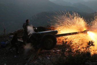 Syrian army personnel fire a cannon in Latakia province, close to the Turkish border in Syria. (Photo by Alexander Kots/AP)