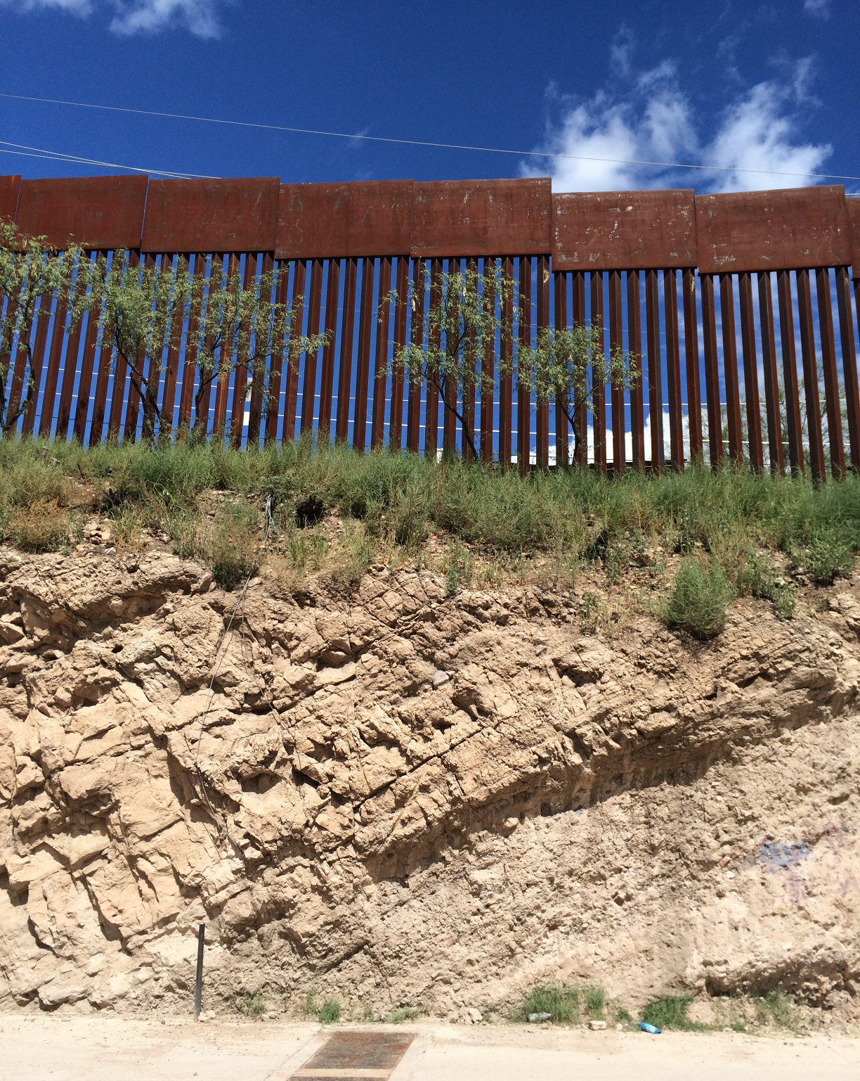 The fence between Nogales, Mexico, and Nogales, Ariz., sits atop a steep embankment. It's 20 to 25 feet high, with 3.5-inch gaps between the bars. (Photo by John Burnett/NPR)