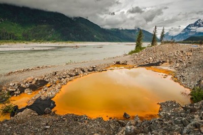 Acidic drainage from the Tulsequah Chief Mine, discolors a containment pond next to the Tulsequah River in British Columbia in 2013. (Photo courtesy Chris Miller/Trout Unlimited)