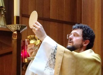 The Rev. Thomas Weise, who serves Catholic churches in Petersburg and Wrangell, celebrates communion during an Easter Vigil. (Photo courtesy Diocese of Juneau)