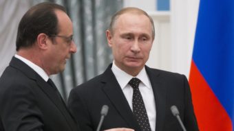 Russian President Vladimir Putin (right) listens to French President Francois Hollande as they leave their news conference in Moscow on Thursday. Alexander Zemlianichenko/AP