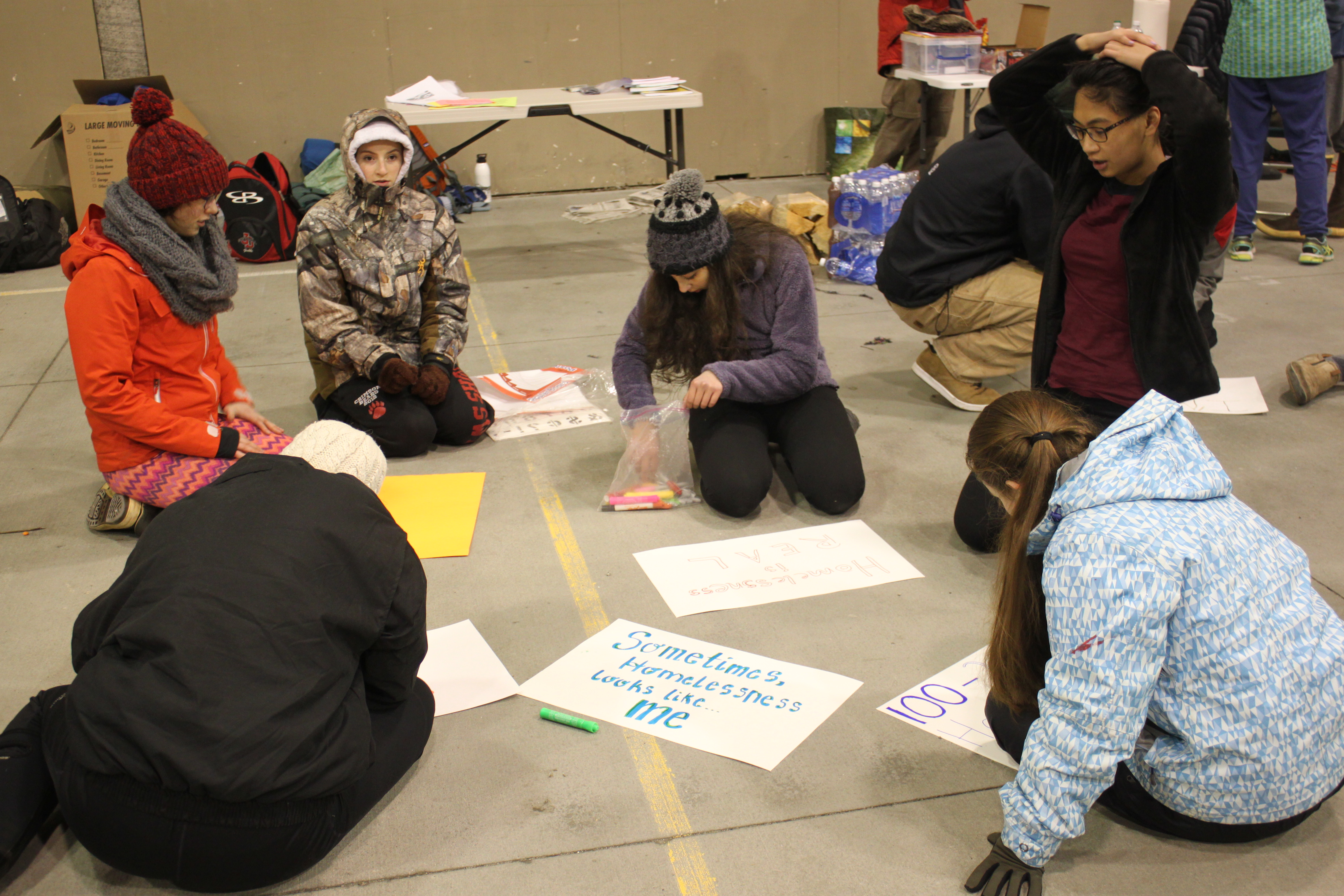 During the sleep out, students made signs about youth homelessness that they waved outside Mendenhall Mall and Safeway. (Photo by Lisa Phu/KTOO)