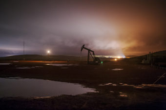 Flares and electric lights on oil well pads illuminate low-hanging clouds near Watford City, North Dakota. Andrew Cullen