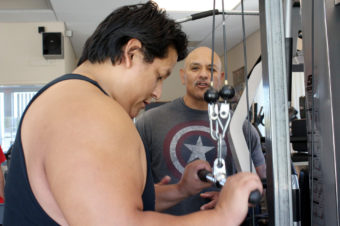 Jorje Mendez has lost more than 45 pounds through weightlifting and other lifestyle changes. Trainer Johnny Gonzales, right, helps prediabetic patients at the gym he set up at the Lake County Tribal Health Clinic in California. Farida Jhabvala Romero/KQED