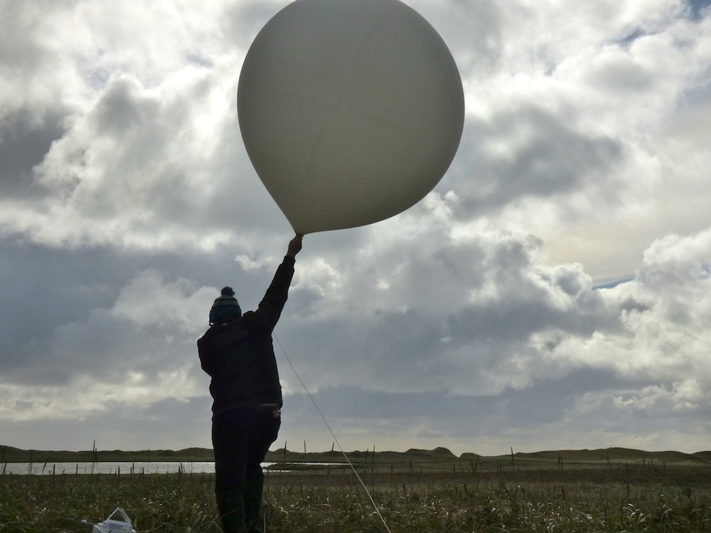 William Wells, about to launch a weather balloon on St. Paul Island, Alaska. (Photo by John Ryan/KUCB)