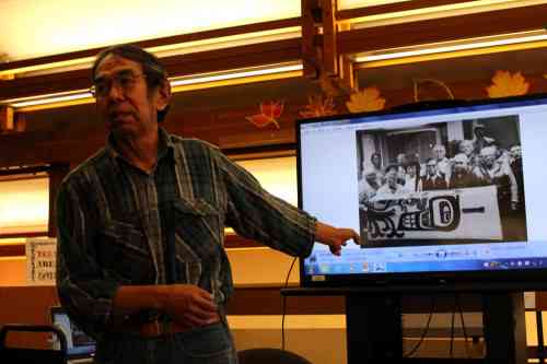 Sam gives a presentation at the library. He points to a picture of himself with Tlingit elders who encouraged him to pursue his interest in cemetery caretaking. (Photo courtesy of Bob Sam)