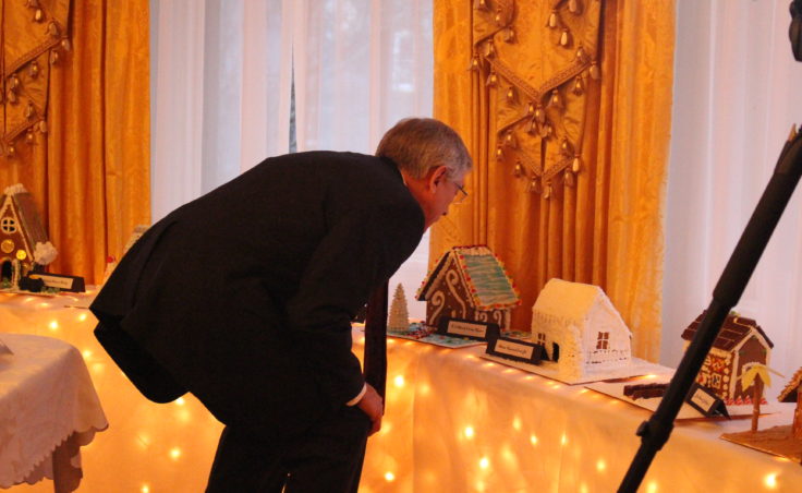 Lt. Governor Byron Mallott peers at gingerbread houses made my children. (Photo by Elizabeth Jenkins/KTOO)