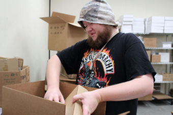 Michael Palone, 26, who has Asperger's syndrome and mild autism, is paid to assemble packages through a program run by The Arc in Union City, Calif. The program may close soon due to budget problems. Melissa Hellmann for KQED