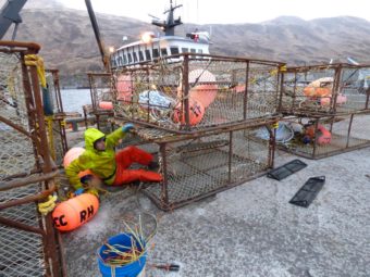 Commercial fisherman Ryan Fry sets up crab pots outside the F/V Farrar Sea in Unalaska. (Photo by Annie Ropeik/KUCB)